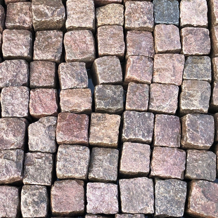 Rødlige granitsten i et tæt mønster. Inspiration til valg af granitfarve.