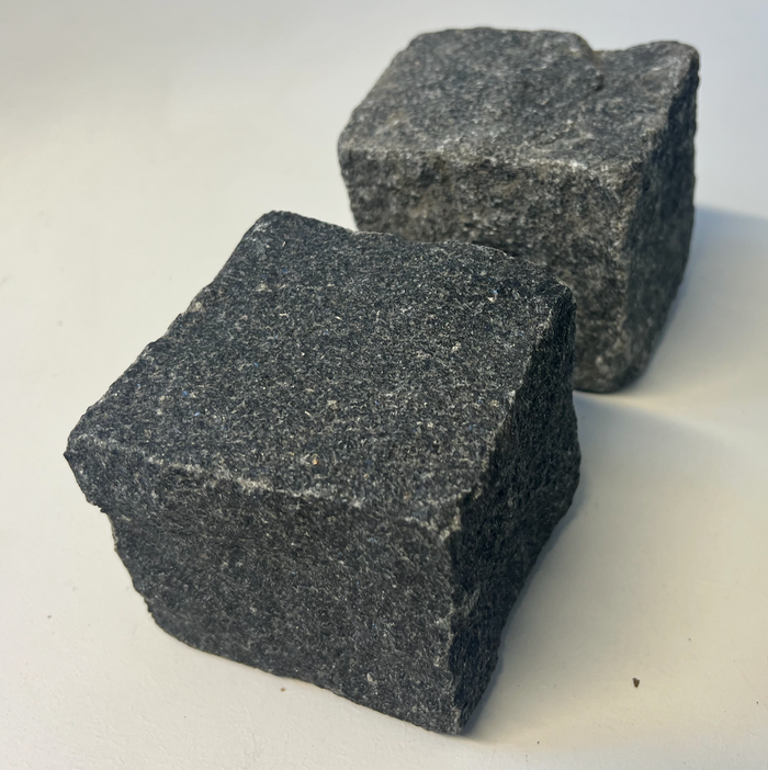 To sorte granitsten, brugt til belægning.