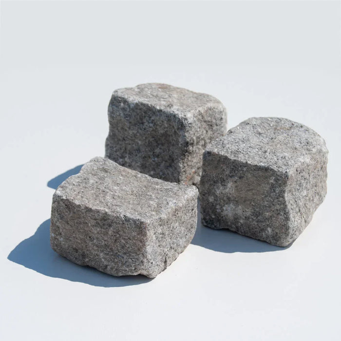 Tre grå portugisiske granitsten på hvid baggrund.