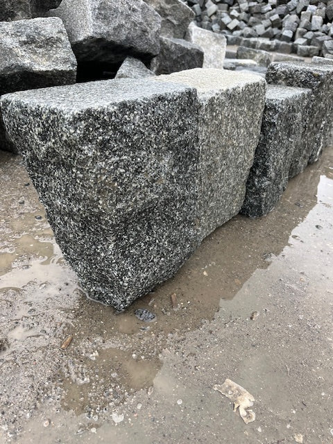 gråsorte, stokhuggede granit kantsten/bedafgrænsning (g399) på vådt underlag.