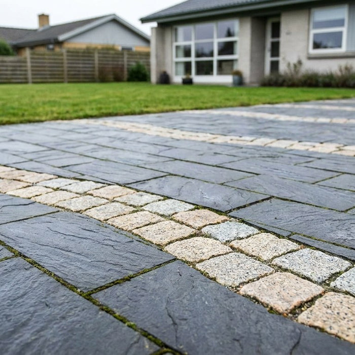 Flot ny indkørsel med lyse soldaterfliser og mørke chaussesten lagt i mønster