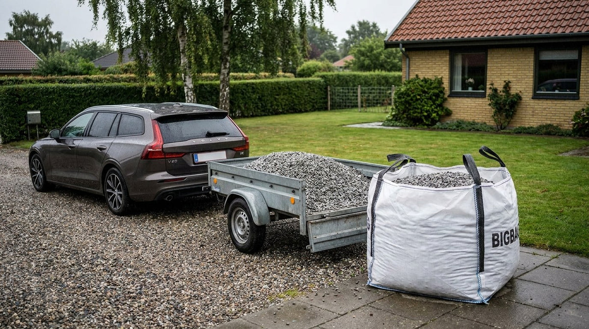 En person skovler grus fra en trailer ned i en trillebør til et gør-det-selv belægningsprojekt i haven