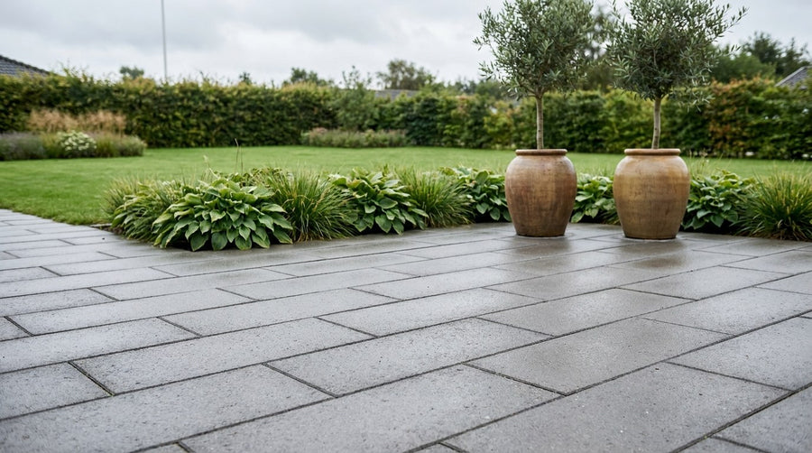 Nylagt terrasse og indkørsel med en kombination af betonfliser og chaussesten i granit