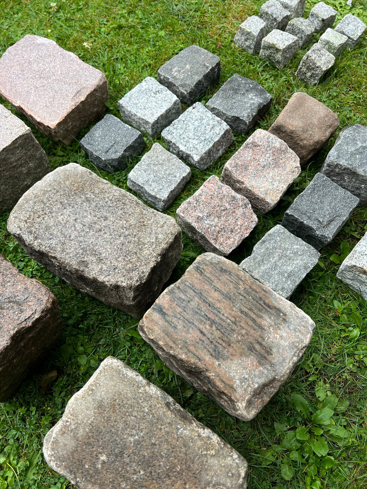 Granitsten til belægning: Chaussesten, brosten og mosaiksten på græs.