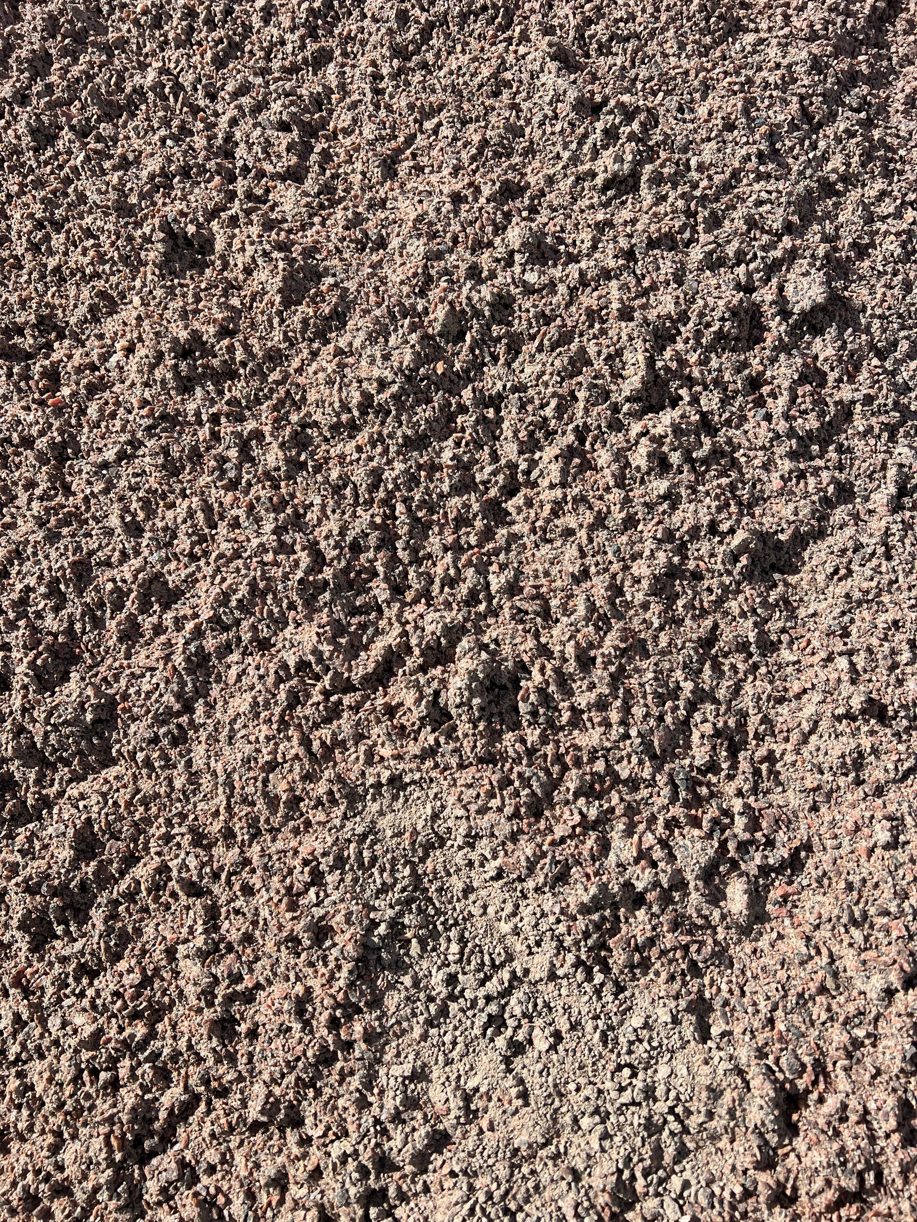 Nærbillede af stenmel. Tekstur af små sten i brunlige nuancer.