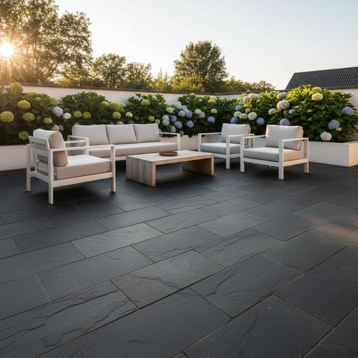 Sort skiferterrasse med havemøbler og hortensia. Moderne og minimalistisk design.