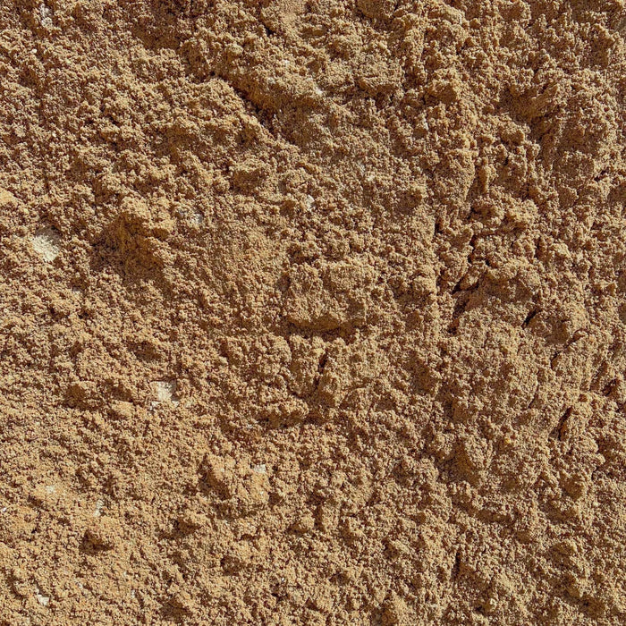 Nærbillede af sand, der bruges til at bygge en indkørsel.