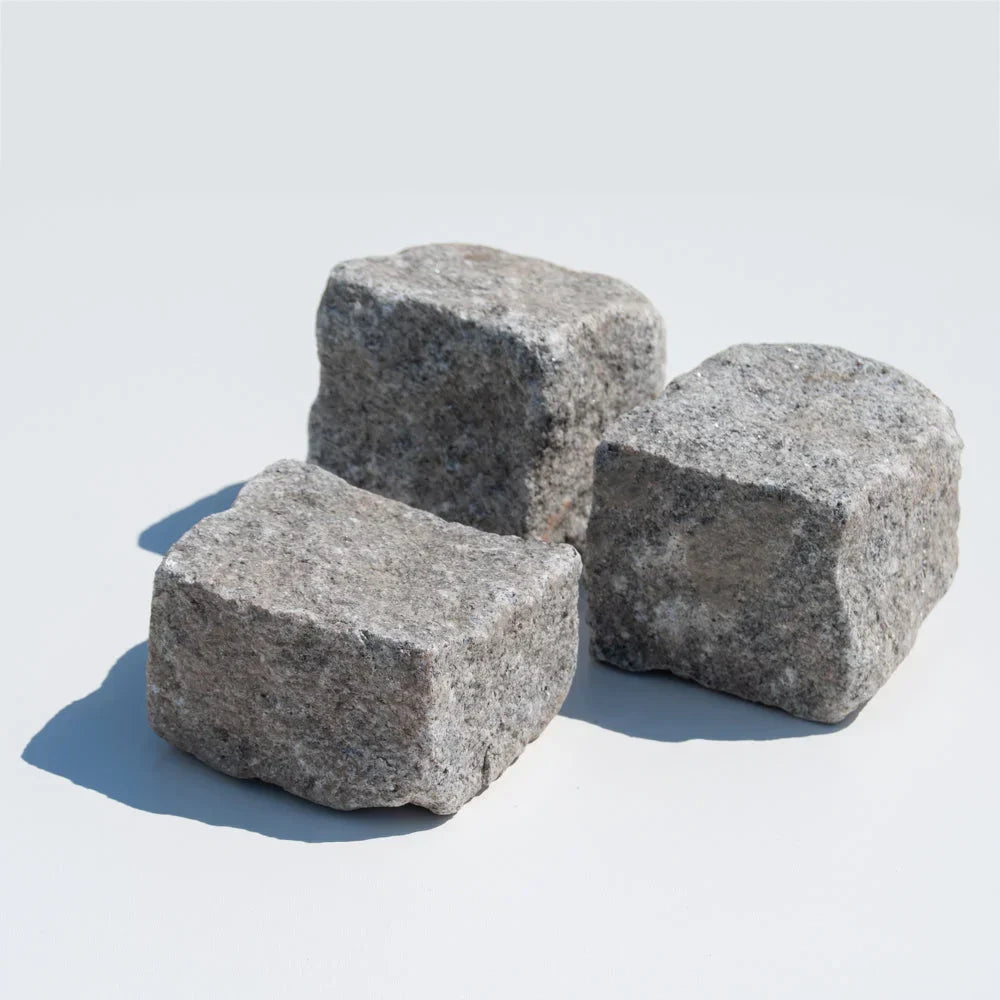 Tre grå portugisiske granitsten på hvid baggrund.