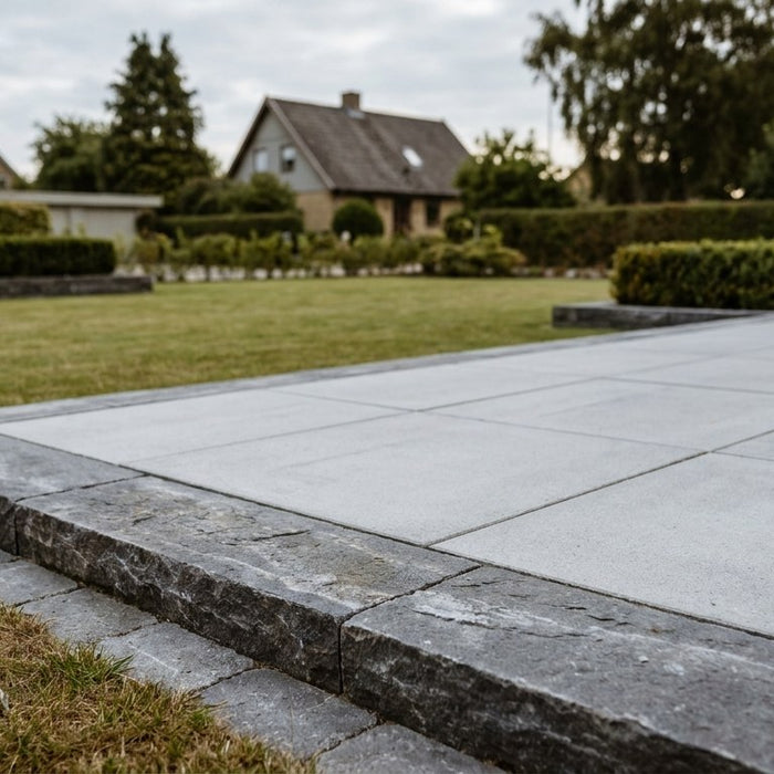 Nyanlagt terrasse med en bred og solid bordursten som afslutning mod græsplænen