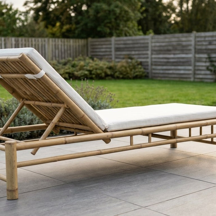 Smukke bambusmøbler placeret på en tør og velanlagt fliseterrasse i en dansk have