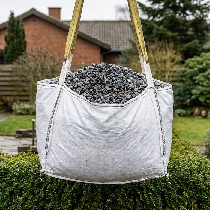 En nyanlagt indkørsel med et jævnt lag af mørke granitskærver og stramme stålkanter