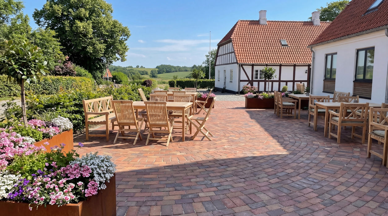 rødbrune teglklinker (malmø) på terrasse med havemøbler og idyllisk landskab i baggrunden.