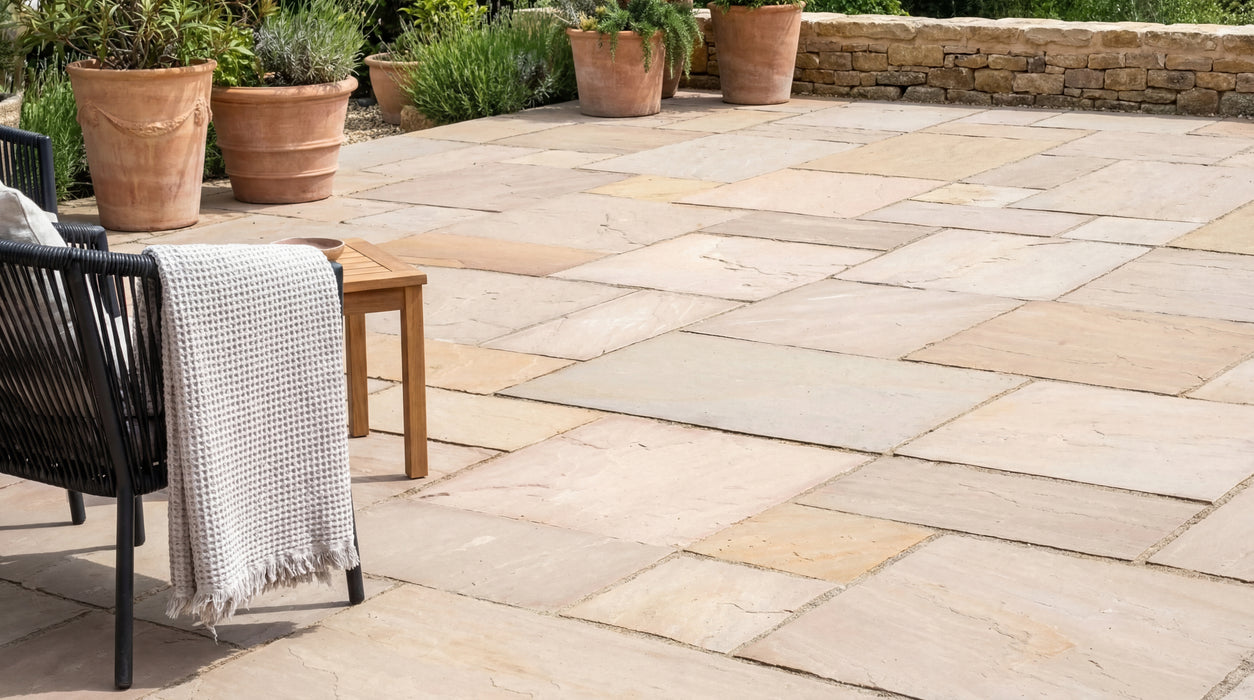 sandsten i romersk mønster, naturel, lagt som terrasse med møbler og krukker.