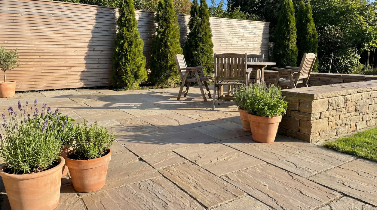 oliven sandsten i romersk mønster som terrassebelægning med havemøbler.