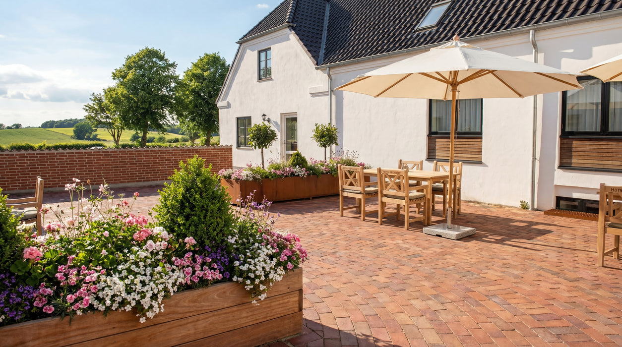 rødbrune teglklinker "malmø" på terrasse ved hvidt hus. klinkerne er lagt i smukt mønster.