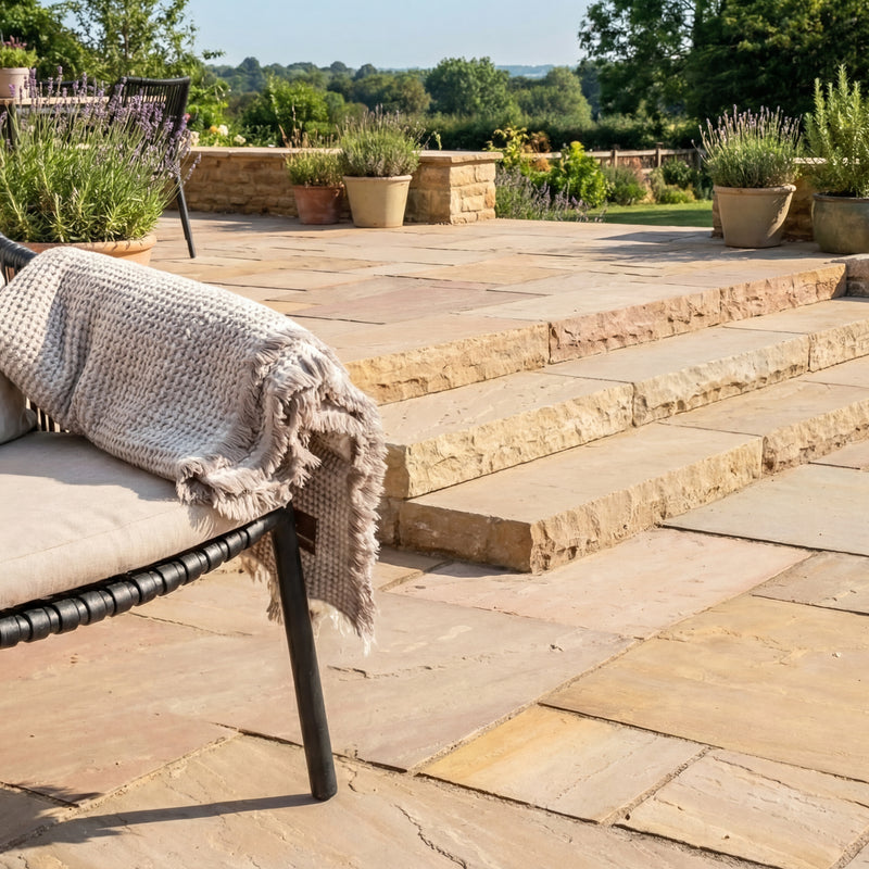 sandfarvede sahara trappetrin i sandsten på terrasse med møbler og beplantning.